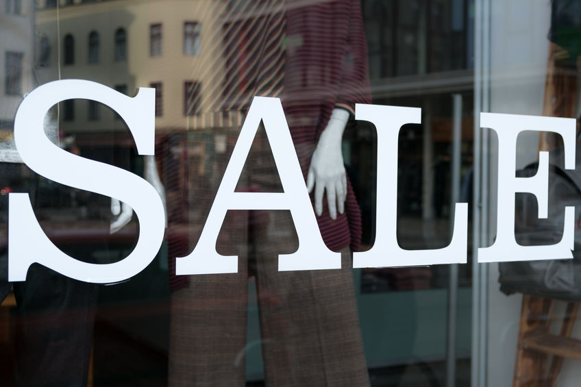 A mannequin's hand on a promotional window display featuring industrial screen printing.