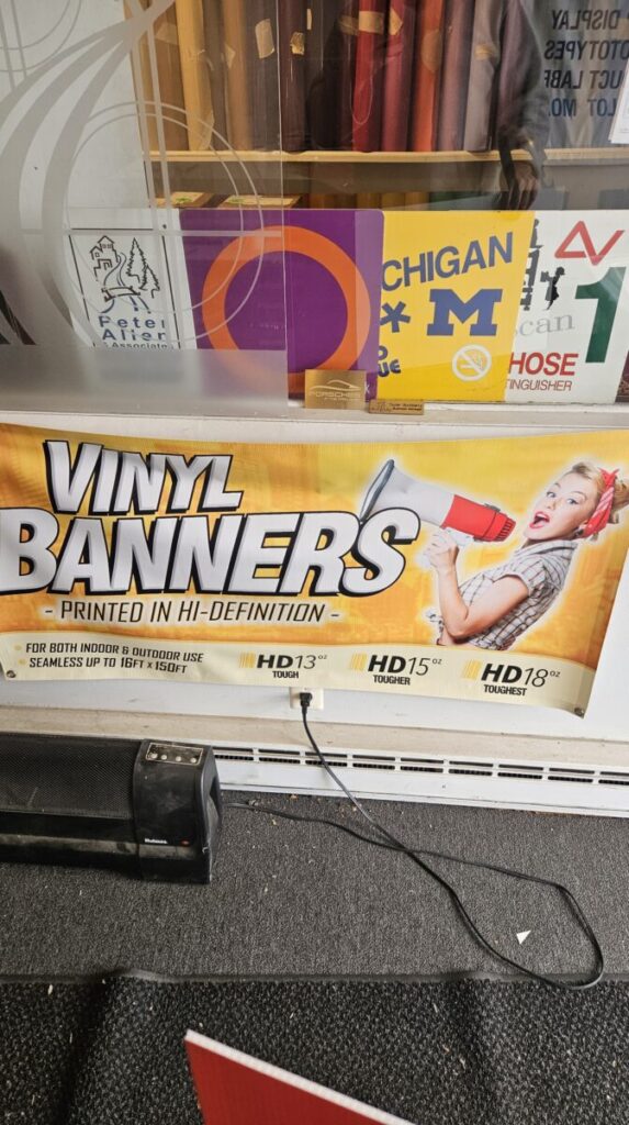 Vinyl banners in the window of a store for promotional purposes.