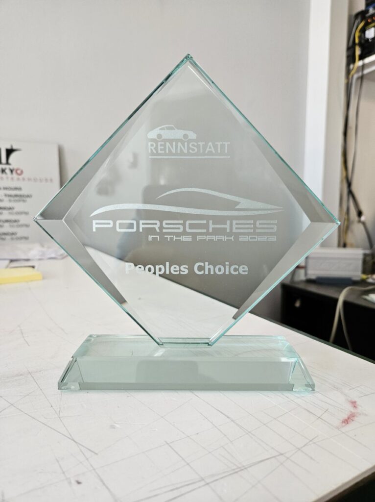 A glass award with the words "Porsche's Choice" on it, showcased alongside Vinyl Signs & Banners in Ann Arbor.