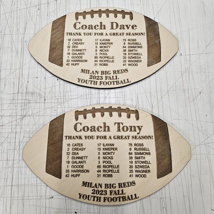 A football shaped plaque with a football and a coach.